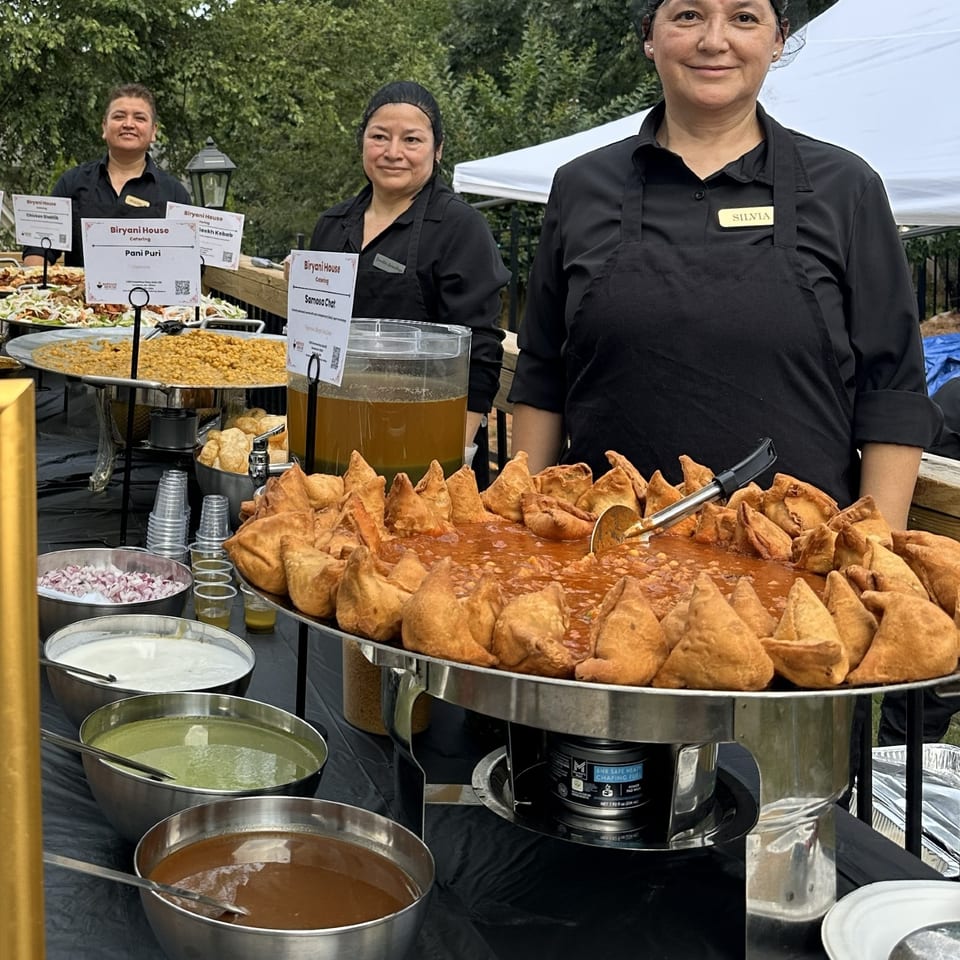 Catering staff serving samosa chaat outdoors