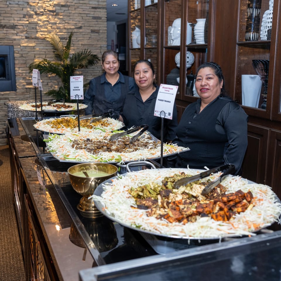 Catering team behind a buffet of appetizers