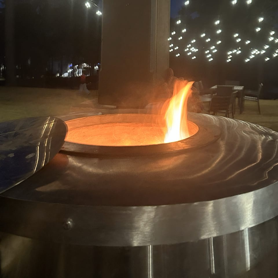 Flame rising from a tandoor at an evening event